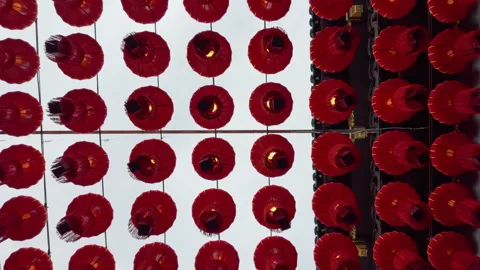 Red Lanterns Suspended in Rows Above Temple Roof Against Overcast Sky Stock Footage 336772637