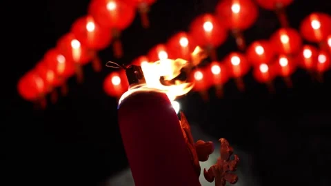 A red large incense stick is lit in front of a red lantern Vídeo Stock 314389170