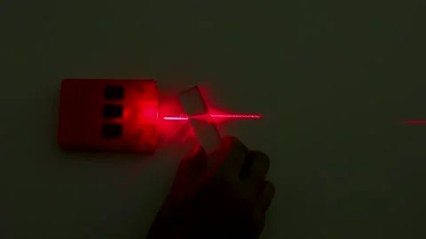 Red Laser Beam Refracting Through Glass Prism in Physics Experiment Stock Footage 347696258