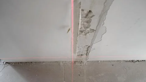 Red laser level lines on unfinished wall and ceiling corner during constructi Stock Photos