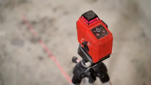 Red laser level tool projecting a line on the floor Stock Photos