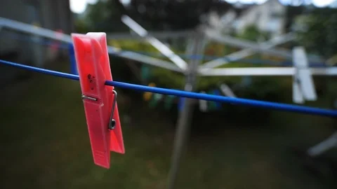 Red Laundry Peg clothes pin hanging on washing line outdoors. Slow motion Vídeos de archivo 113723794