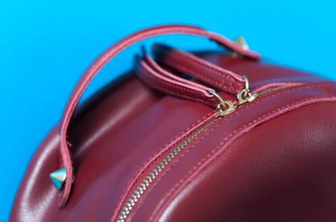 Red leather backpack on blue background Stock Photos