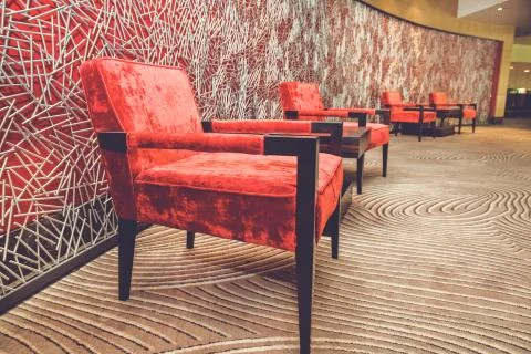 Red leather comfortable sofa and armchair in lobby of hotel Foto stock