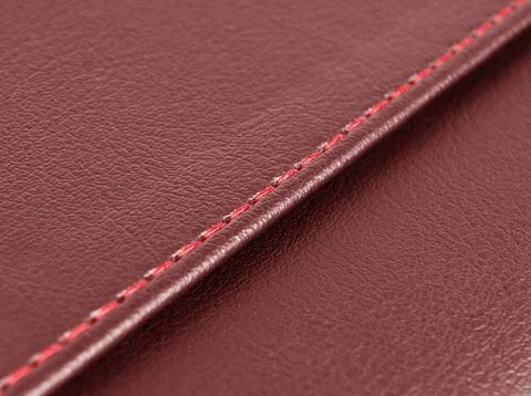 Red leather texture with red stitching. Part of perforated leather details... Stock Photos