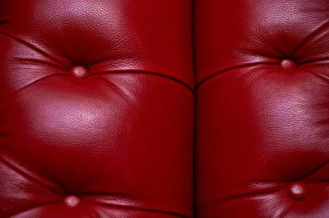 The red leather upholstery of sofa, padding with buttons.Texture. Stock Photos