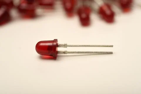 A red LED on the background of a pile of LED elements. One LED. Stock Photos