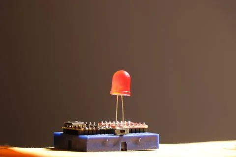 Red led connected on blue circuit board with microcontroller Stock Photos