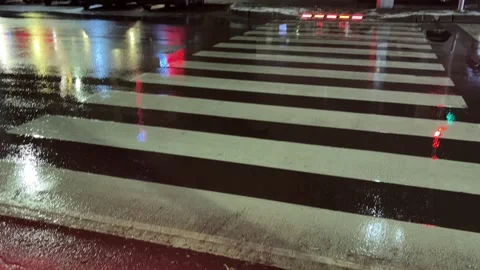 Red LED warning lights embedded in the asphalt at a pedestrian crosswalk duri Stock Footage 326881641