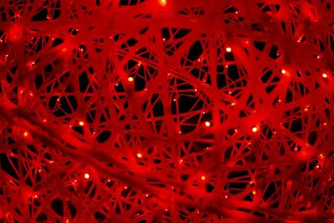 Red LEDs in the web. The texture of the web in bright light. The woven thread Stock Photos