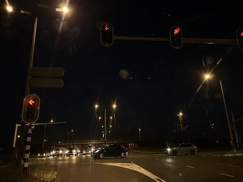 Red left turn arrow traffic light at night in Amsterdam South business Stock Photos