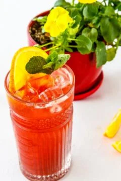 Red lemonade with a slice of lemon and orange in a glass on the table Stock Photos