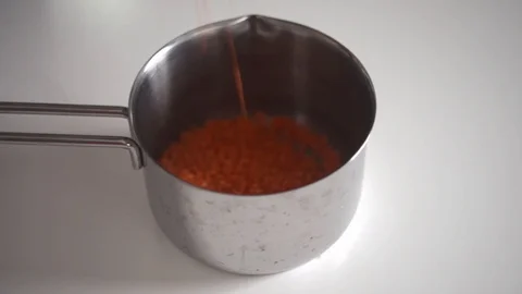 Red lentils fall into the pan Stock Footage 122076169