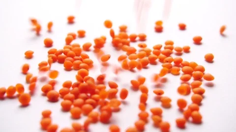 Red lentils falling against white background Stock Footage 86838995