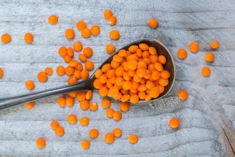 Red lentils on a spoon macro Stock Photos