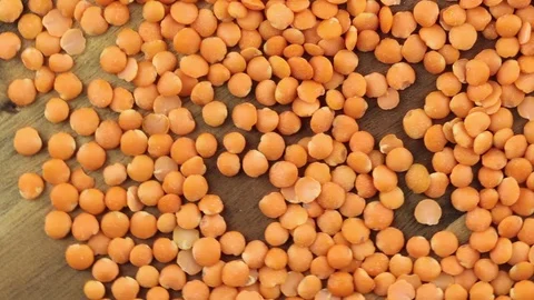 Red lentils top view rotating background texture Stockbeeldmateriaal 124834221