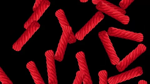 Red Licorice Candy Pieces Falling Against a Solid Black Background Stock Footage 345037696