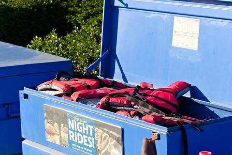 Red life jackets sit inside an open blue storage box at a Long Beach paddle boat Stock Photos