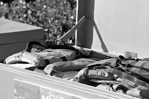 Red life jackets sit inside an open blue storage box at a Long Beach paddle boat Stock Photos
