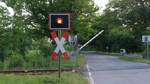 Red light and lowering of the barrier at a railway crossing in Germany. Stock Footage 240185032