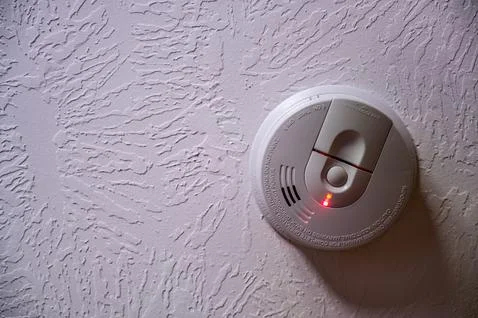 Red light batter indicator on a smoke detector mounted on a ceiling Stock Photos