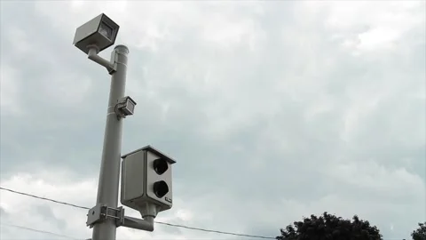 Red light camera picture and video two cameras on silver post with dark clouds Stock Footage 247753369