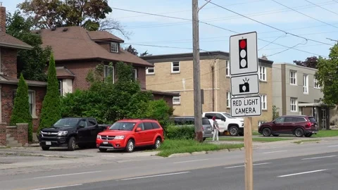 Red light camera sign next to a quiet side street Stock Footage 283599642