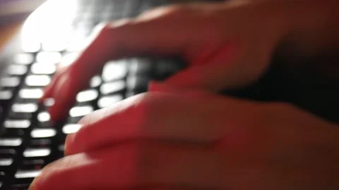 In the red light close up shot of person's hands typing on keyboard Stock Footage 134241985