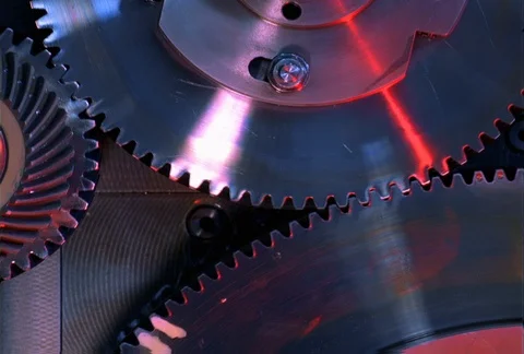 Red light glowing on three interlocking gears as they turn in close-up Stock Footage 86885812