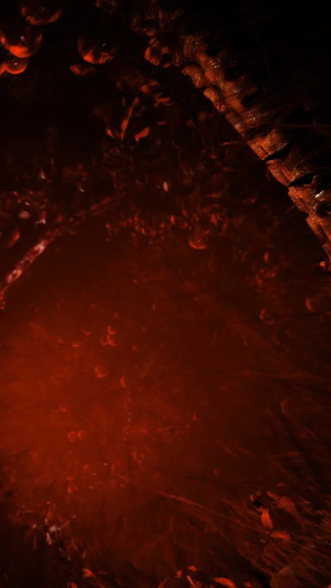 Red light shines in dark cave with rocky walls and scattered debris Stock Footage 332212840