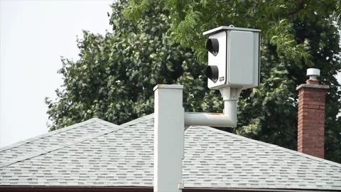 Red light silver picture camera protruding from post with car vehicle traffic Stock Footage 248711918