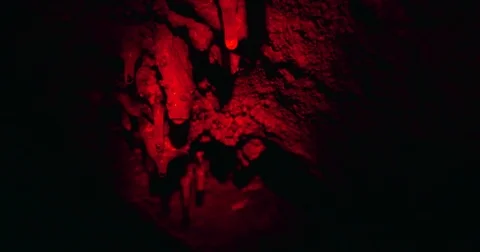 Red Light Sweeps Over Rock Formations in a Dark Cave Stock Footage 71595479