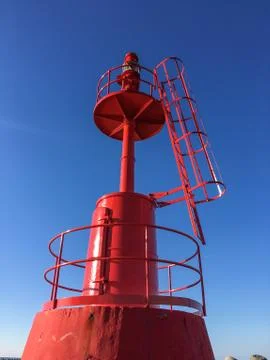 Red Lighthouse inside at port with blue sky Foto stock