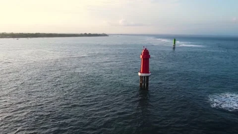 Red lighthouse in the ocean on sunset Stock Footage 156335409