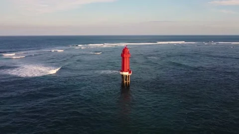 Red lighthouse in the ocean on sunset Stock Footage 156853968