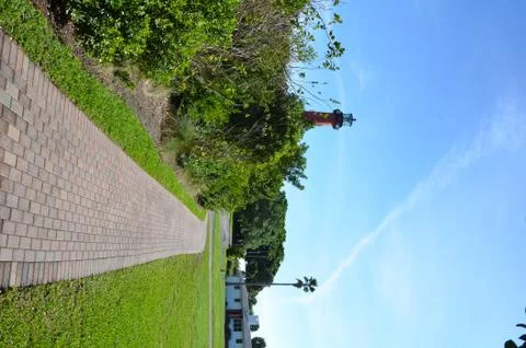 Red lighthouse with path or trail and trees Stock Photos