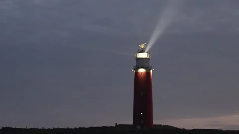 Red Lighthouse with Rotating Light Beam at Night Stock Footage 337998137