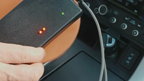 Red lights on black device blink when man holds wooden round under the device Stock Footage 153484447