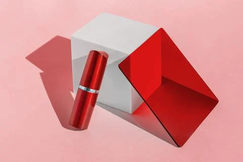 Red lipstick container with mirror and cube on pink background 스톡 일러스트