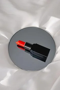 Red lipstick on a round mirror with reflection. Stock Photos