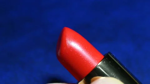 The red lipstick is wrapped in a case. Real time, contains people, blue backgrou Video stock 149218614