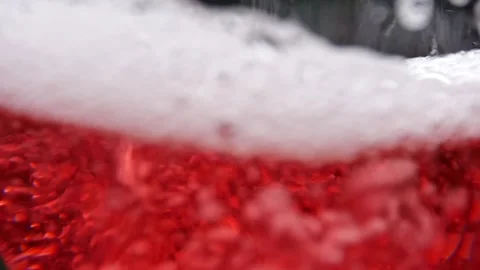 The red liquid with bubbles is poured into a glass vessel. Stock Footage 165125530