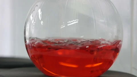 Red liquid is bubbling in a flask under laboratory conditions. Stock Footage 119304674