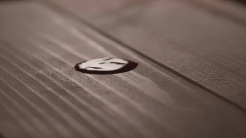 Red liquid drop falling onto brown wooden planks surface in cinematic slow .. Stock Footage 337682259