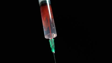 Red liquid is mixed in a syringe with white liquid on a black background Stock-Footage 139715080