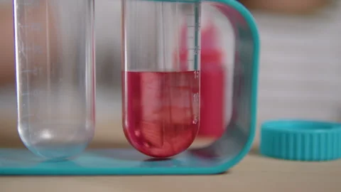 Red liquid swirling in laboratory test tube Stock Footage 312686801