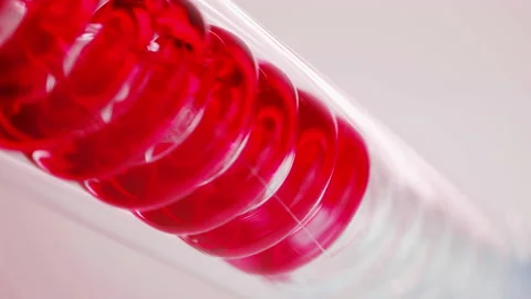 Red liquidity flows through spiral pipe. Stock Footage 144004581