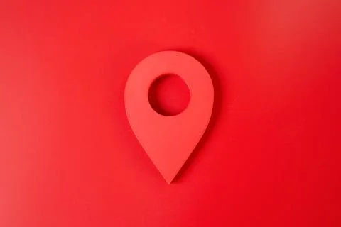 Red location pin button on a red background. Minimalist location and surround Stock Photos