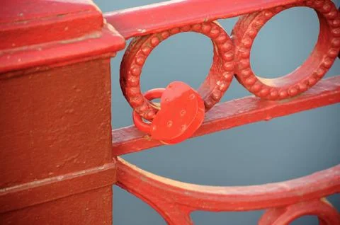 Red lock on the grid of the red bridge Stock Photos