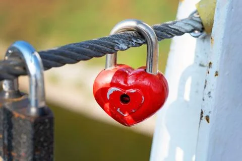 Red lock hang on a cable on a bridge. Symbol of eternal love and fidelity met Foto stock